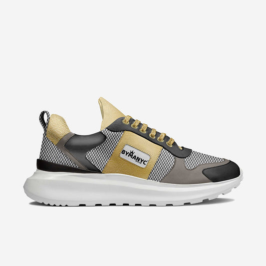 Gold, black and gray vegan sport sneaker by BYMANYC New York on a white foamed sole, shown from the side.