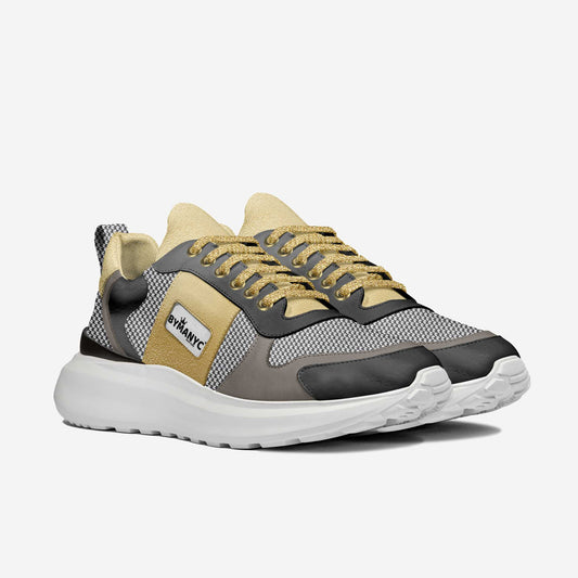 Gold vegan sport sneaker by BYMANYC New York with a mesh panel and a white foamed sole, angled view.