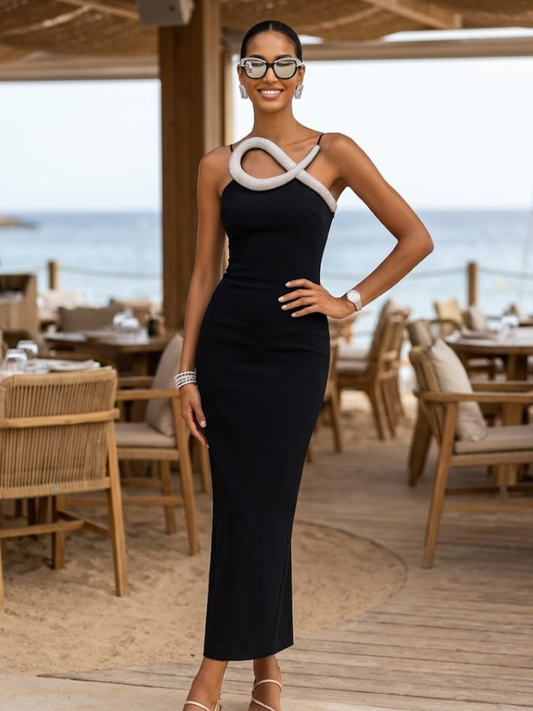 Women's fitted strapless column maxi dress in black by BYMANYC New York, shown in a warm-weather setting.