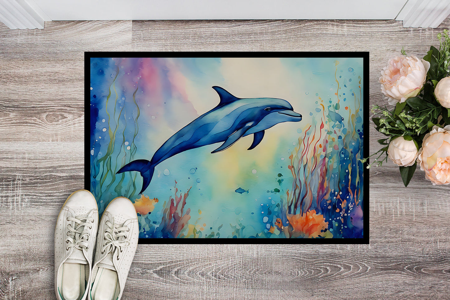 The 24 by 36 inch Dolphin artwork doormat seen from above on pale wood boards, a pair of shoes at its edge for scale.
