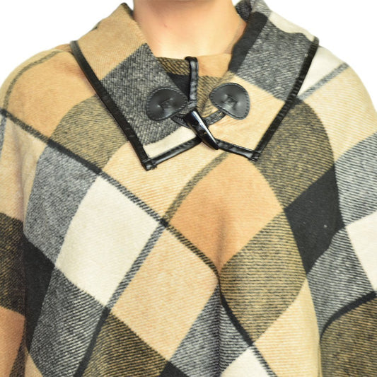 Close view of the plaid cape collar, its two dark toggles and the dark piping along the edges