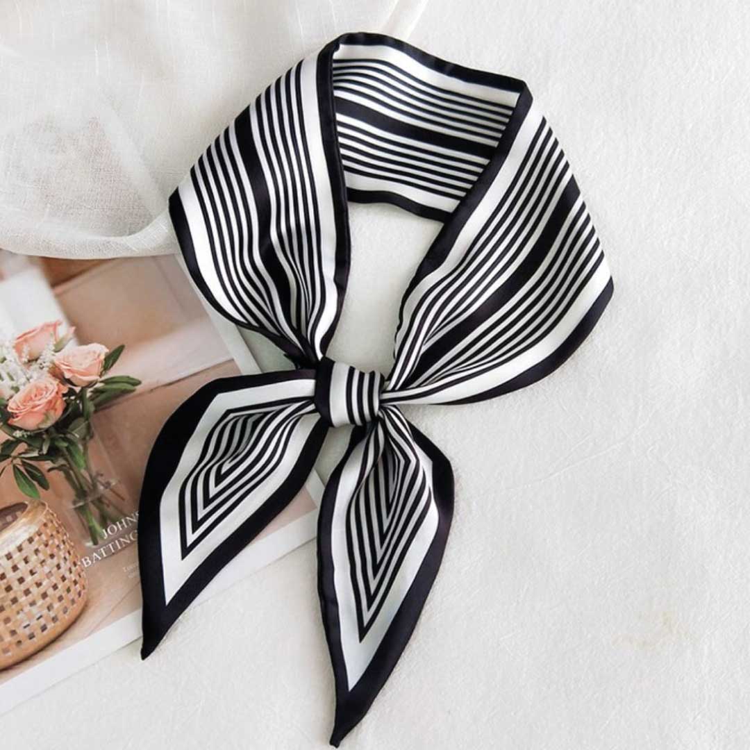 Black colorway, a narrow silk neck scarf in black and white stripes knotted into a loop