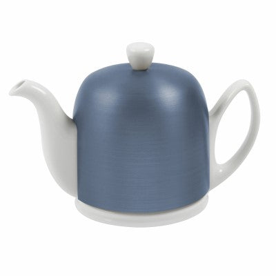 White porcelain teapot under a cobalt blue metal bell that covers the body down to the base.