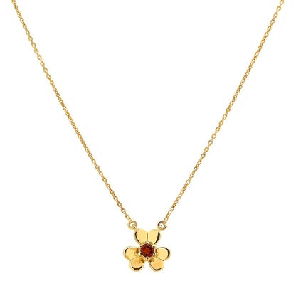Garnet version on white, a small red stone in prongs at the heart of three gold tone petals