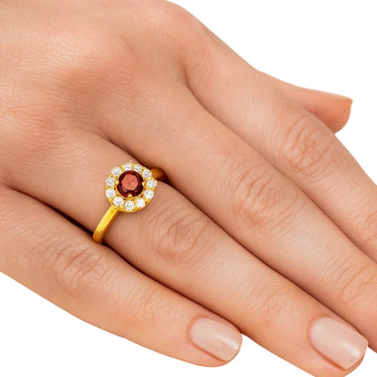 Hessonite garnet halo ring worn on a woman's hand, seen from above
