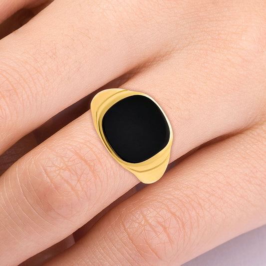 Black onyx signet ring with a cushion stone worn on a woman's finger
