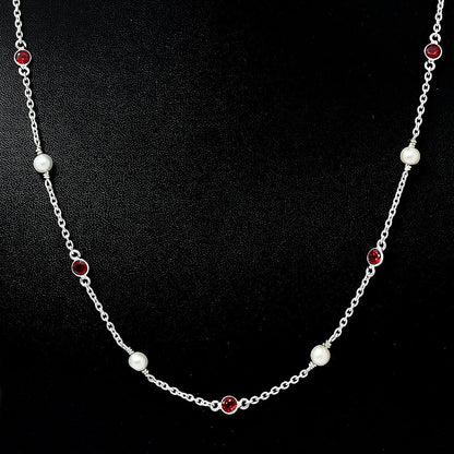 Garnet version on black, white pearls alternating with small red bezel set stones