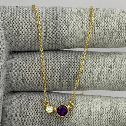 Amethyst version of the two stone necklace draped over gray knit fabric