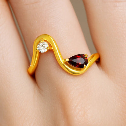 Wave ring with a pear hessonite garnet and a round CZ worn on a finger