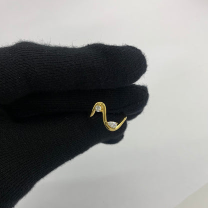 Wave ring with a pear white zircon held between two gloved fingertips