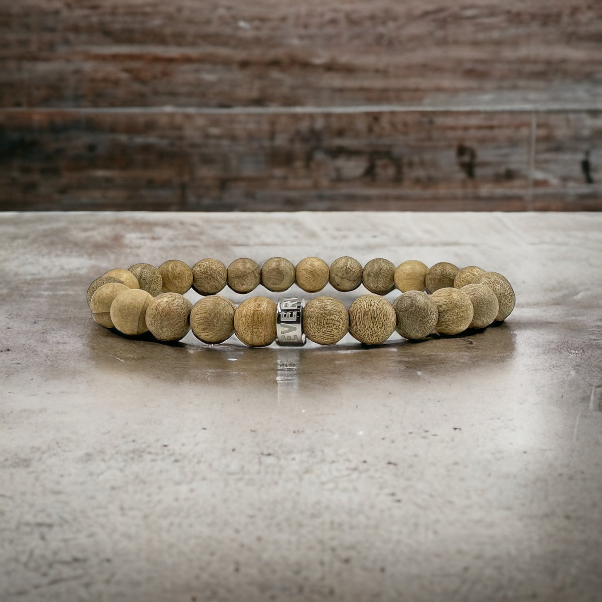 Cascade Ashbark camphor wood beaded bracelet, shown on a concrete surface