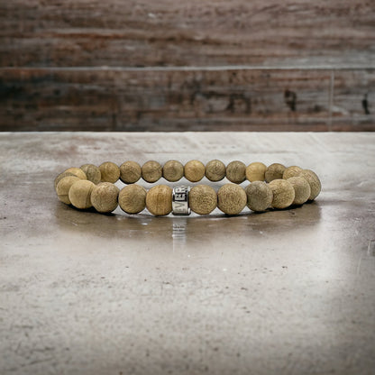 Cascade Ashbark camphor wood beaded bracelet, shown on a concrete surface