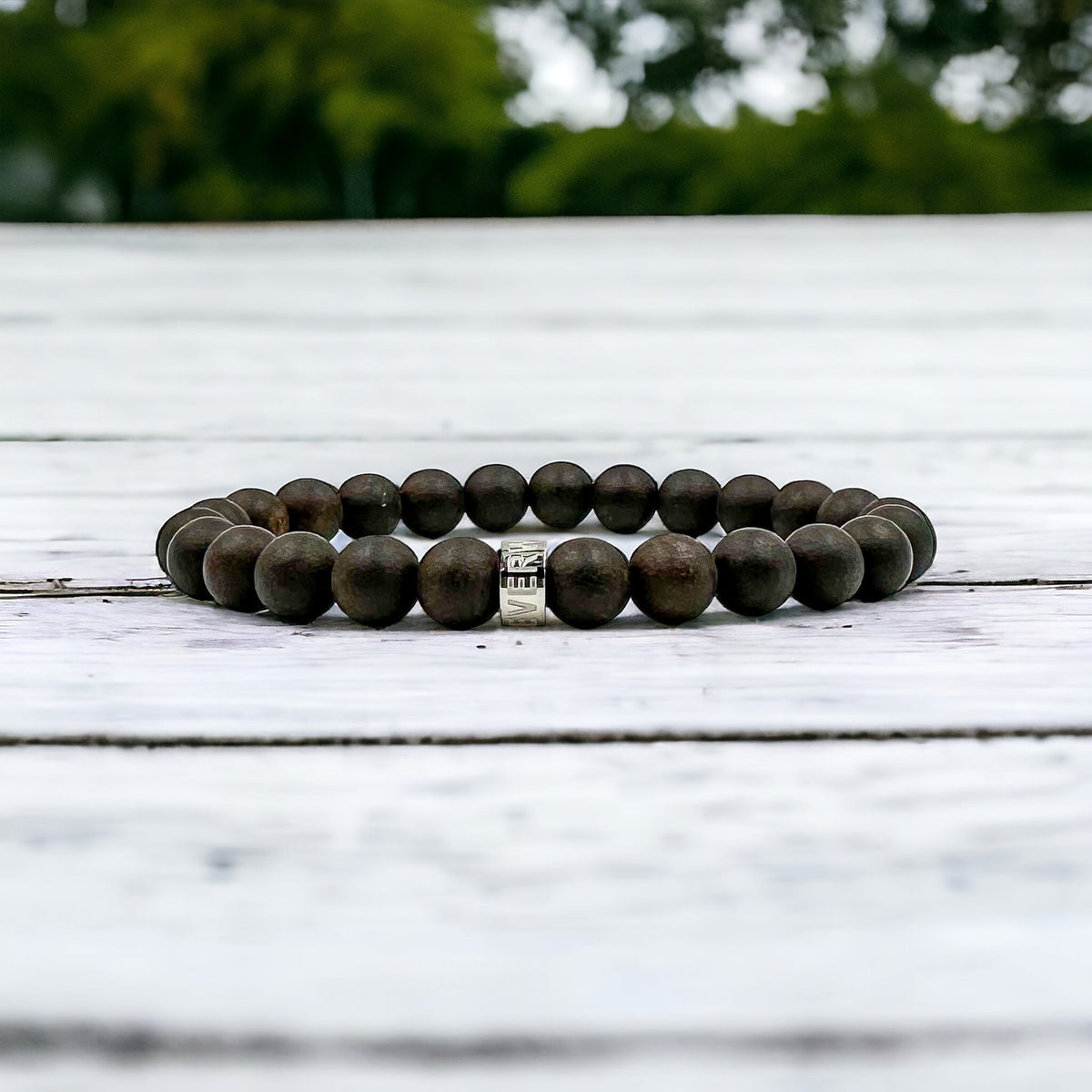 Cascade Blackthorn black sandalwood beaded bracelet, shown on a white wood surface