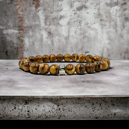 Cascade Boulderline brown sandalwood beaded bracelet, shown on a concrete surface