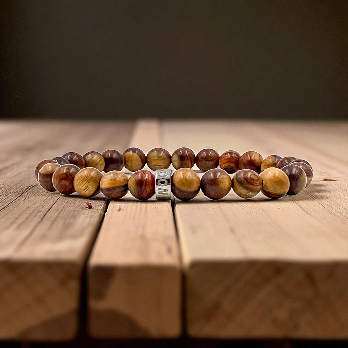 Cascade Cold Canyon mahogany sapwood beaded bracelet, shown on a wood surface