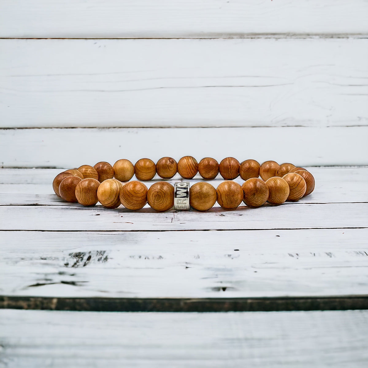 Cascade Tanglepine canary wood beaded bracelet, shown on a white wood surface
