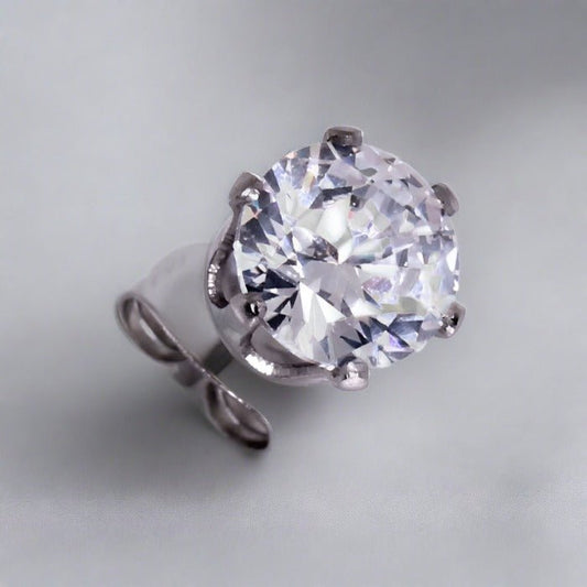 Close view of a six prong clear round CZ stud on a steel post with its clutch