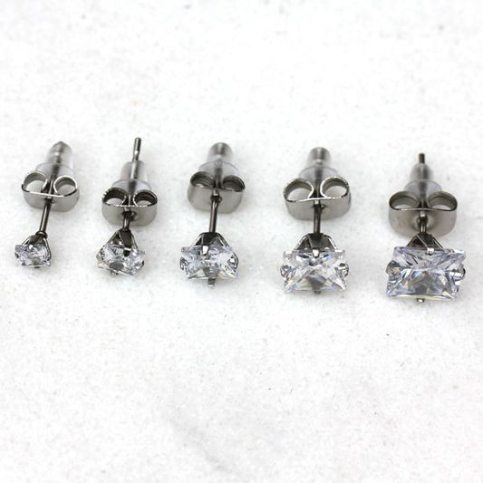 Princess cut CZ studs in five sizes from 3mm to 7mm lined up on white marble