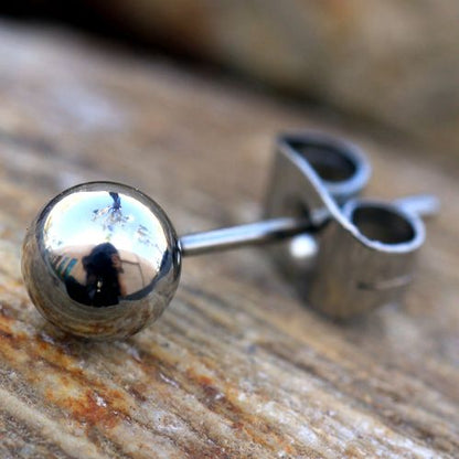 Close view of a mirror polished steel ball stud and its clutch on weathered wood