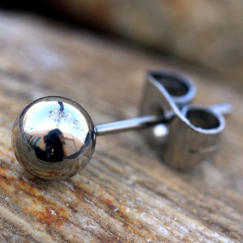 Close view of a mirror polished steel ball stud and its clutch on weathered wood
