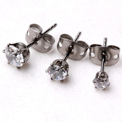 Titanium clear round CZ studs in three sizes with metal clutches on white