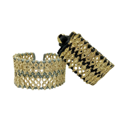 Two wide woven cuff bracelets on white, one with steel blue thread and one with black