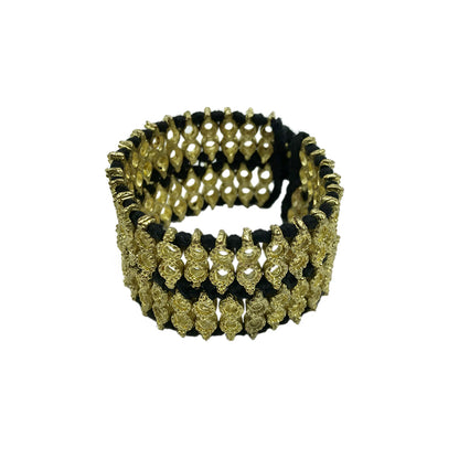 Wide woven cuff bracelet with black cotton thread and gold tone beads, front view on white