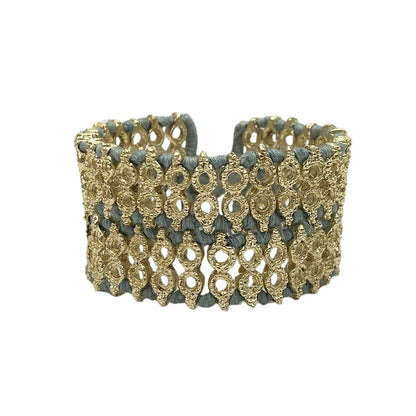 Wide woven cuff bracelet with steel blue cotton thread and gold tone beads, front view on white