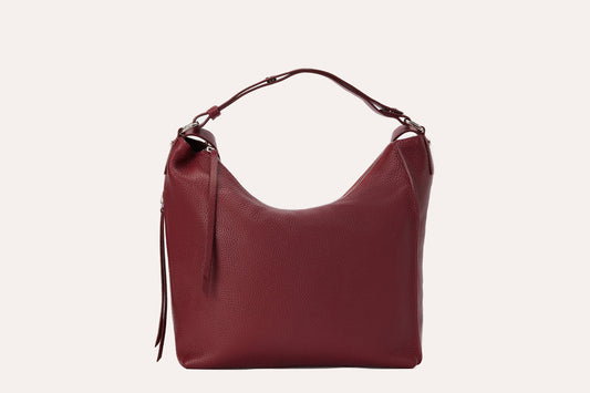 Burgundy pebbled leather convertible backpack purse with a top handle and long zip pulls, front view