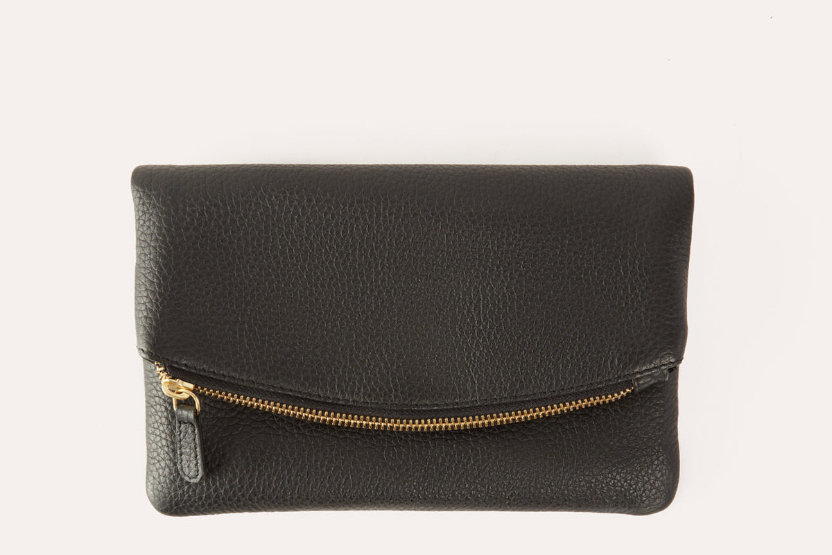 Black pebbled leather fold over clutch with a gold-tone zip running across the fold, front view