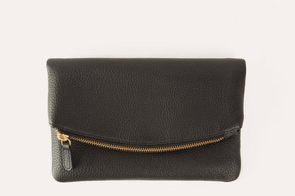 Black pebbled leather fold over clutch with a gold-tone zip running across the fold, front view