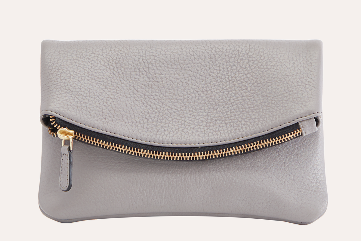 Gray pebbled leather fold over clutch with a gold-tone zip running across the fold, front view