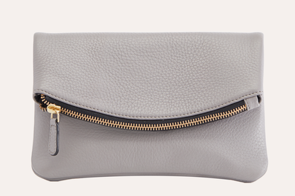 Gray pebbled leather fold over clutch with a gold-tone zip running across the fold, front view
