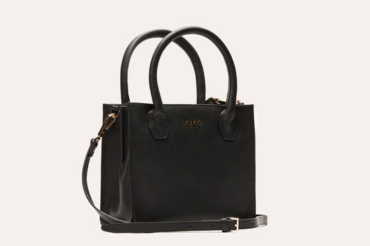 Black pebbled leather mini tote crossbody bag with two rolled top handles and its long strap attached