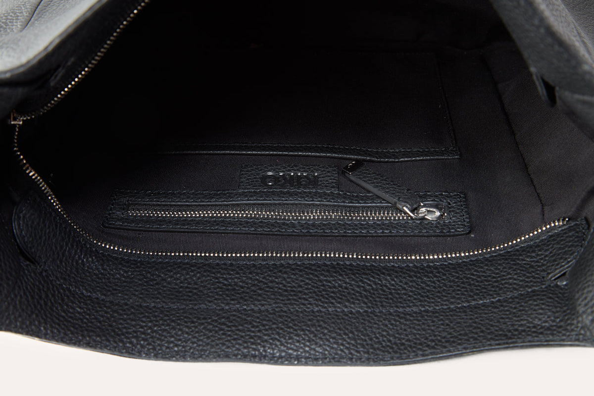 Inside the black hobo bag with the top zip open, showing the lining and a zip pocket on the inner wall