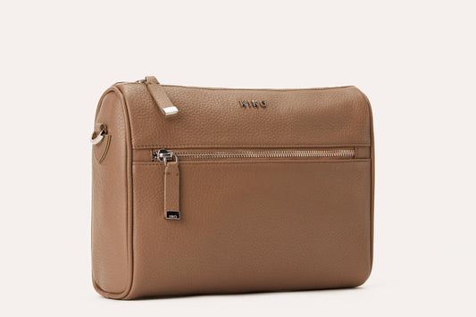 Taupe pebbled leather crossbody bag with a top zip and a front zip pocket, three-quarter view
