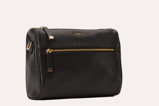 Black pebbled leather crossbody bag with gold-tone zips on the top and front pocket, three-quarter view