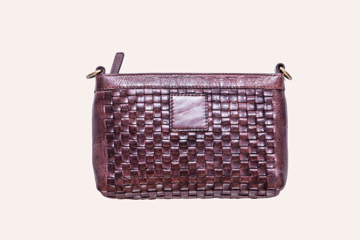 Brown woven leather crossbody bag with a top zip and a smooth leather patch on the front, front view