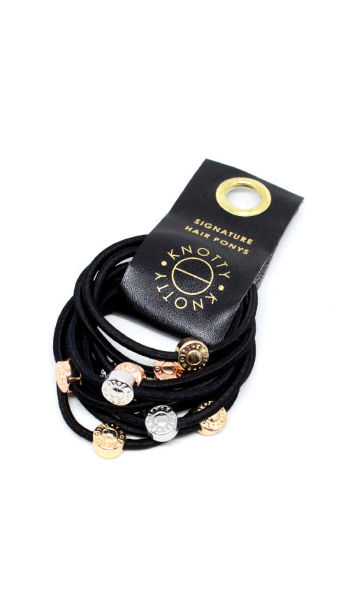 Black hair ties with gold tone, rose gold tone and silver tone beads, fanned from a black branded tab