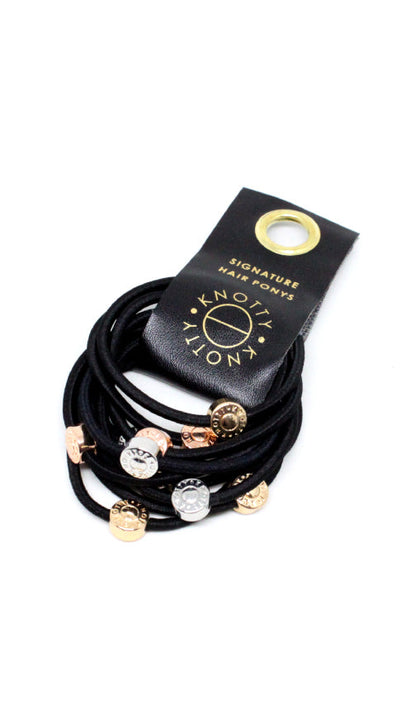 Black hair ties with gold tone, rose gold tone and silver tone beads, fanned from a black branded tab