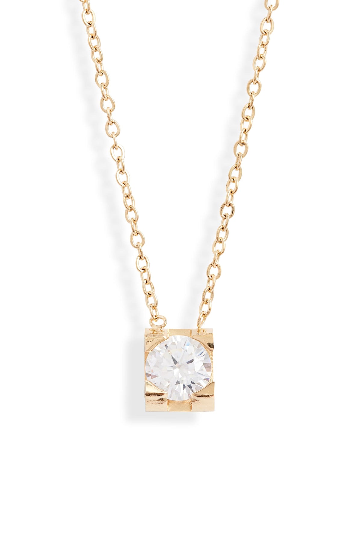 Close view of a round clear crystal held in a square gold tone setting on a cable chain