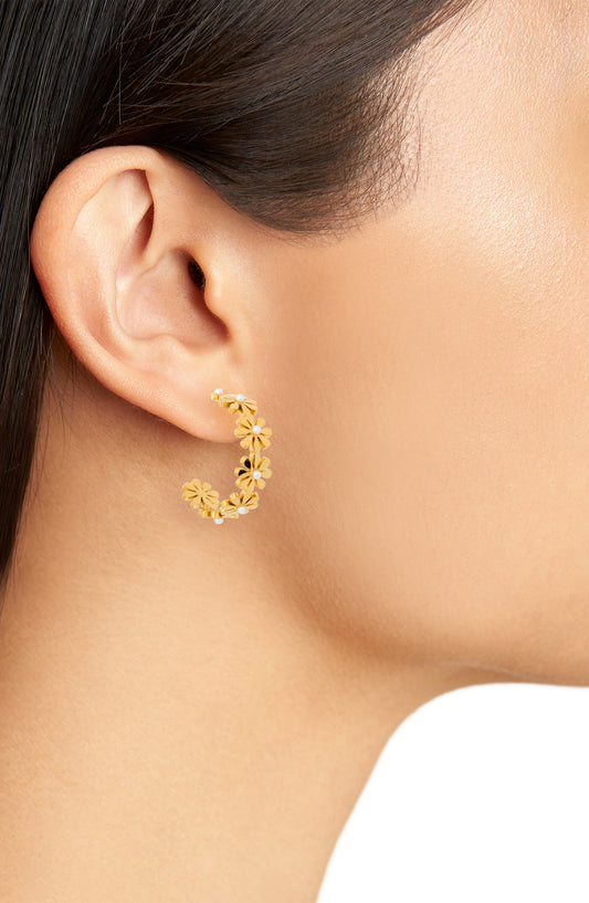 Daisy flower hoop earring worn on the lobe, the gold tone flowers curving under the ear