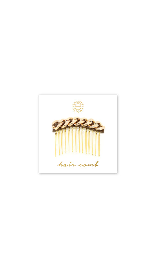 Decorative hair comb with a gold tone chain over metallic leather, on a branded card