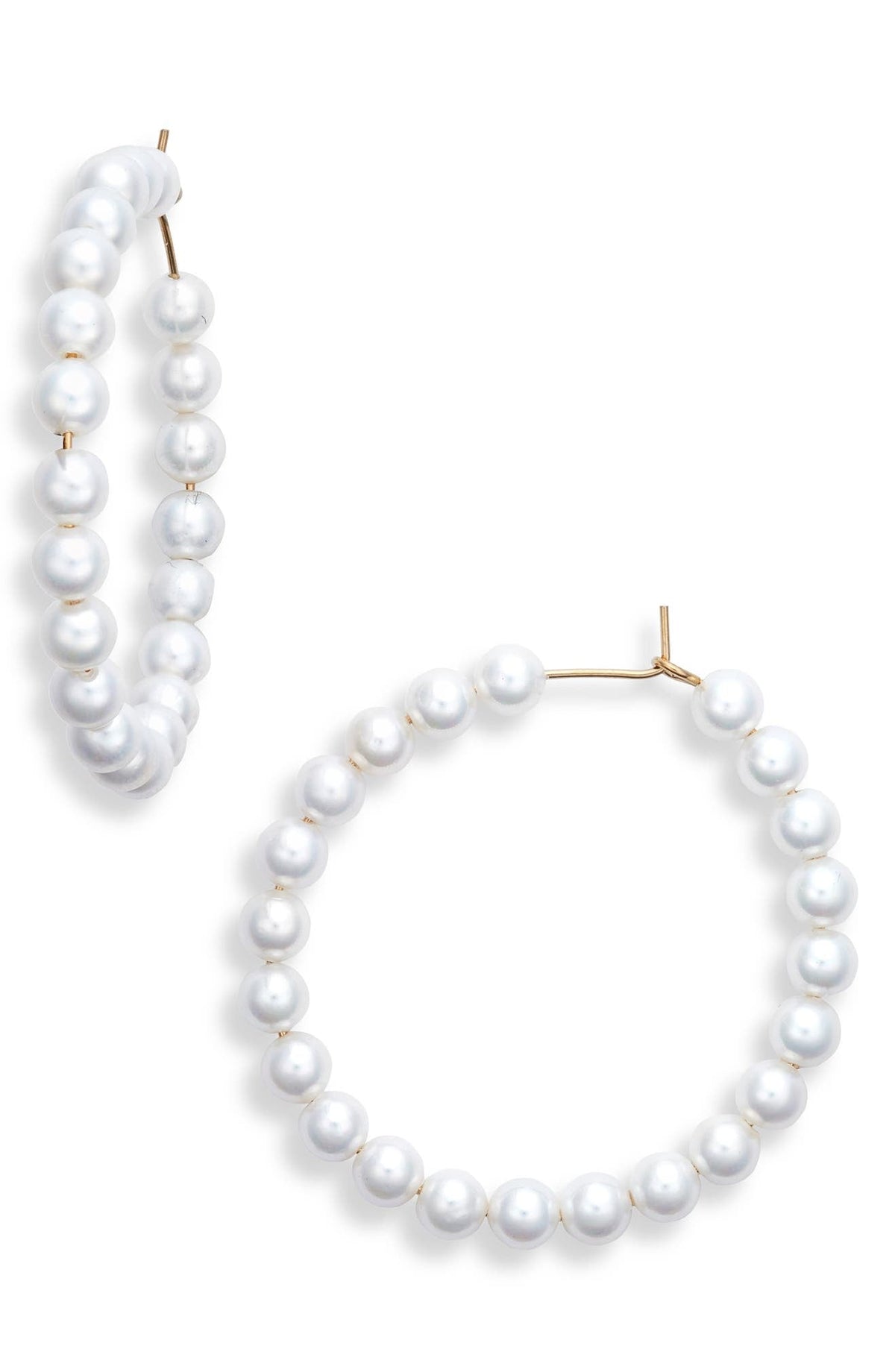 Pearl hoop earrings strung with round faux pearls on a gold tone wire, one hoop shown from the side