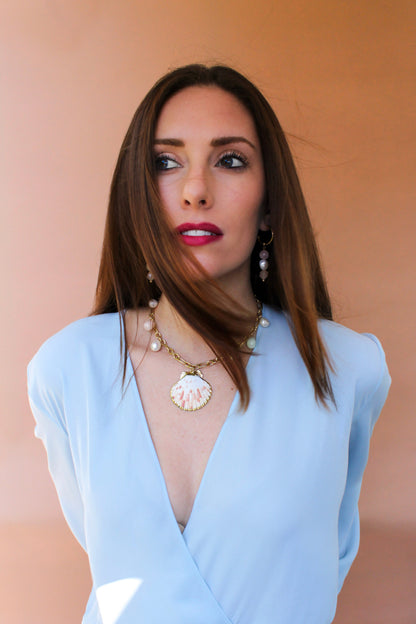 Model glancing down and away, a stacked gemstone drop earring beside her jaw