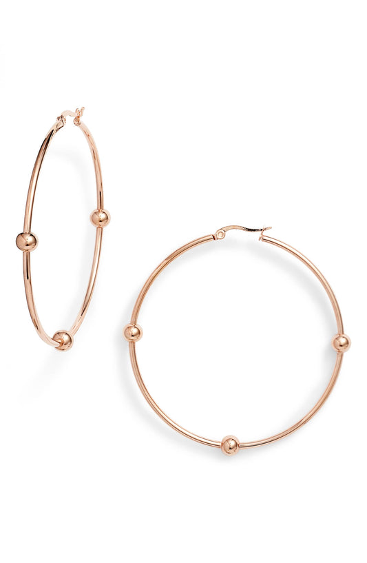Rose gold tone hoop earrings with small metal beads fixed on each thin hoop and a hinged top closure