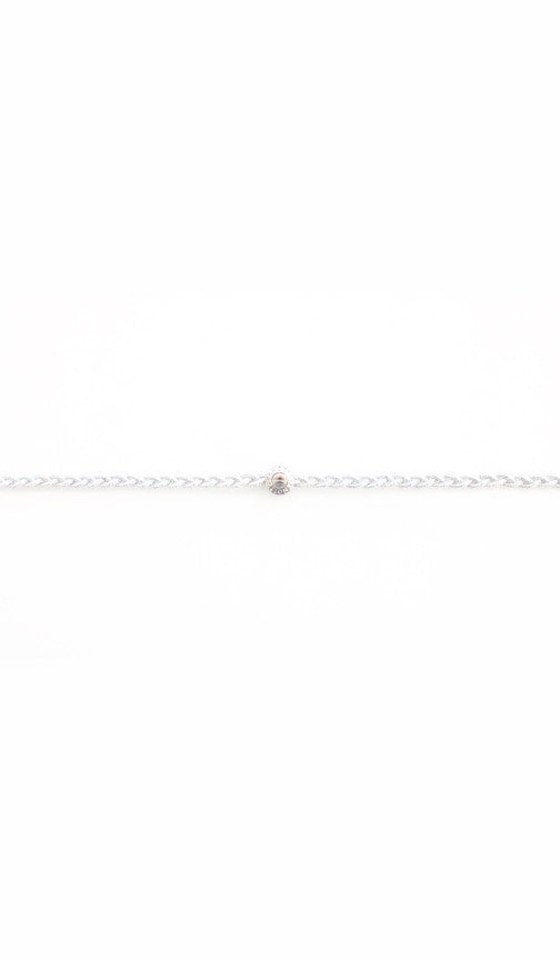 Silver braided headband up close, the twisted cord meeting a dark polished bead
