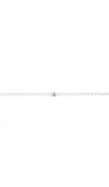 Silver braided headband up close, the twisted cord meeting a dark polished bead