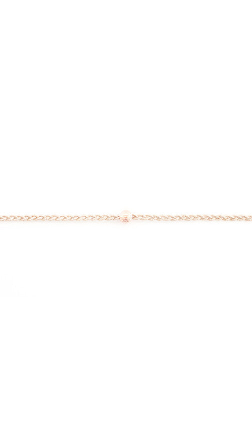 Rose gold braided headband up close, showing the twist of the cord and the bead