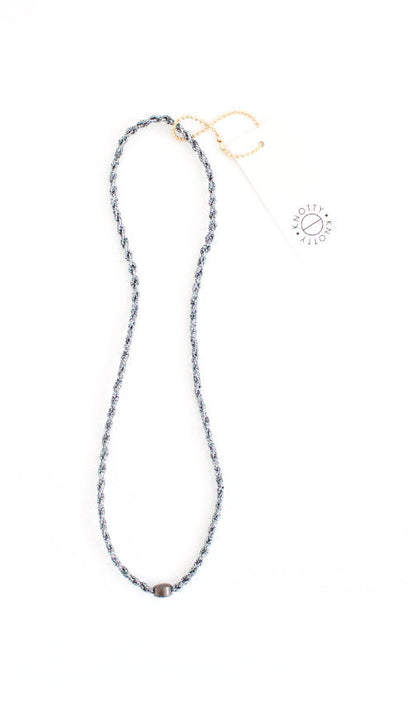 Gunmetal braided headband in dark silver tones with a polished bead, full length